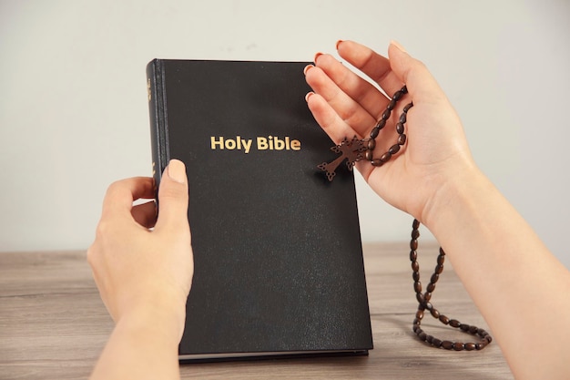 Woman holding cross with Bible