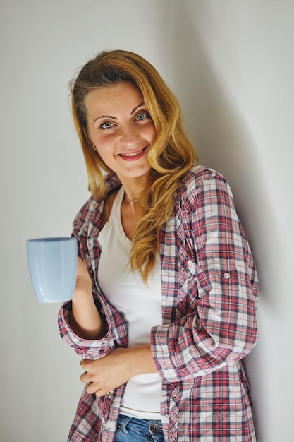 Foto donna che tiene una tazza di caffè. lei è felice