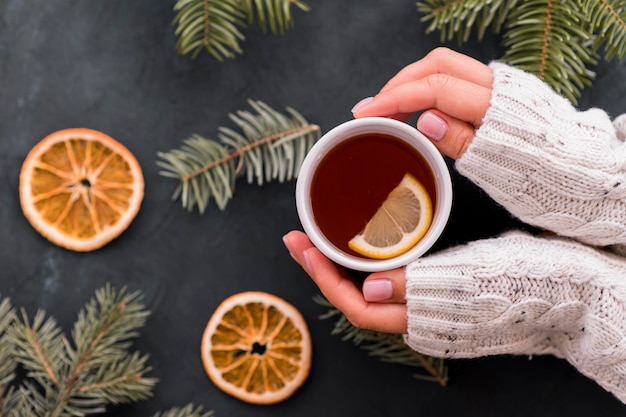 Foto donna che tiene tazza di caffè con fette di limone