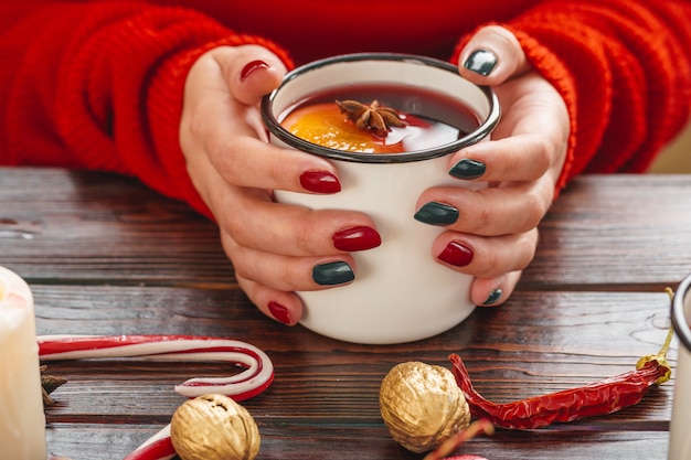 Woman holding cup with mulled wine in her hands