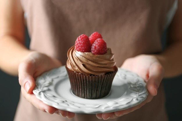 Woman holding cupcake with berries closeup