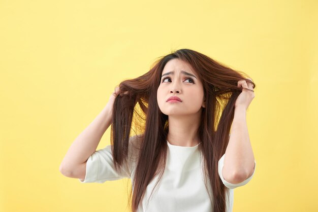 Woman holding damaged hair the hand and looking isolated portrait