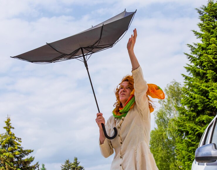 Photo woman holding damaged umbrella against sky