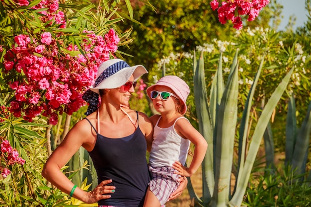 Photo woman holding daughter on hands.