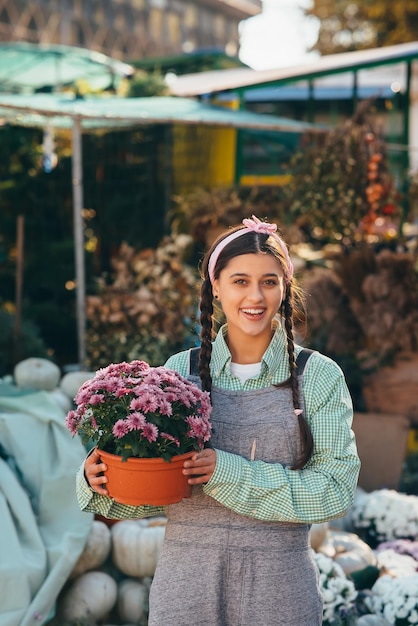 市場の植木鉢に装飾花を持つ女性