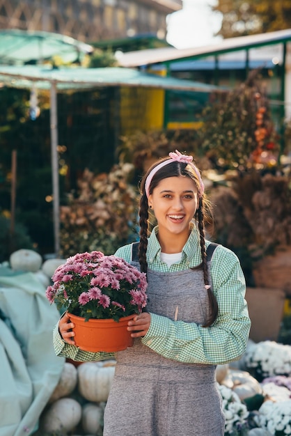 Woman holding decorative flower in flower pot on the market