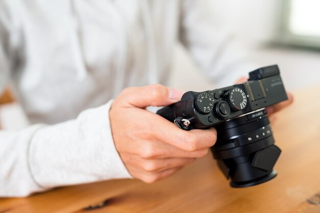 Foto donna che tiene una macchina fotografica digitale a casa