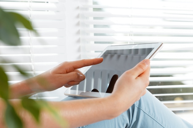 Woman holding digital tablet, closeup