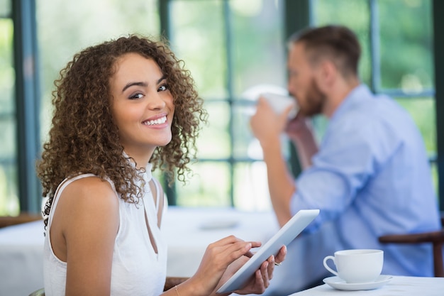 レストランでデジタルタブレットを保持している女性