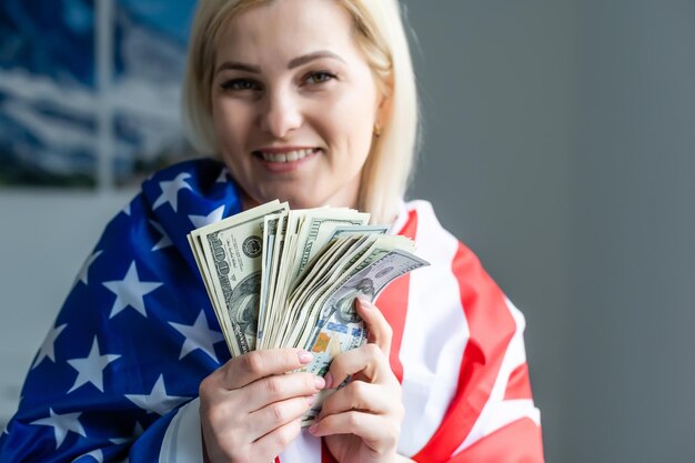 달러와 미국 국기를 들고 여자입니다.