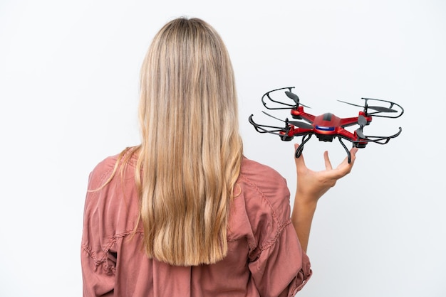 Woman holding a drone over isolated background in back position