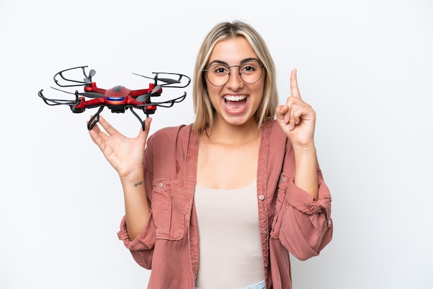 Woman holding a drone over isolated background pointing up a great idea