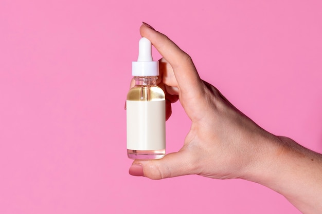 Woman holding a dropper bottle mockup