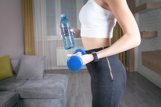 Woman holding dumbbell. Exercise at home