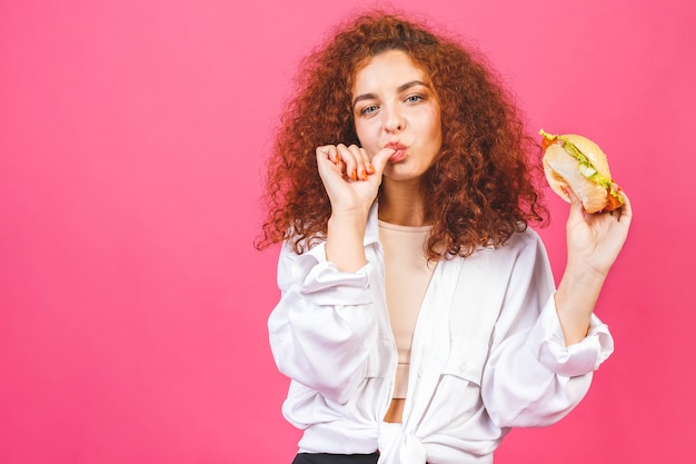 大きなハンバーガーを持って食べる女性