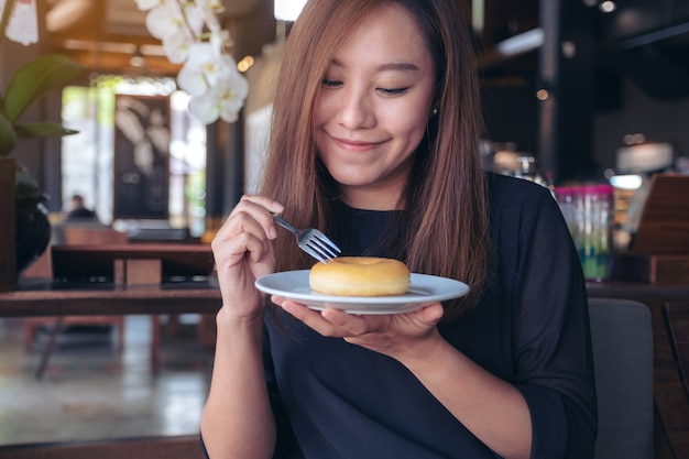 A woman holding and eating a piece of donut