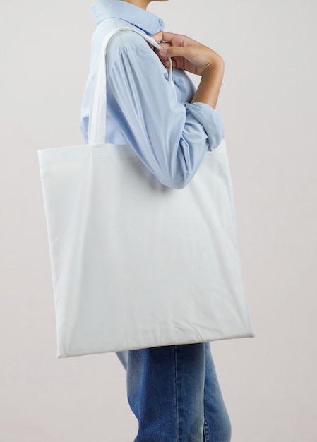 Woman holding eco fabric bag isolate on gray background