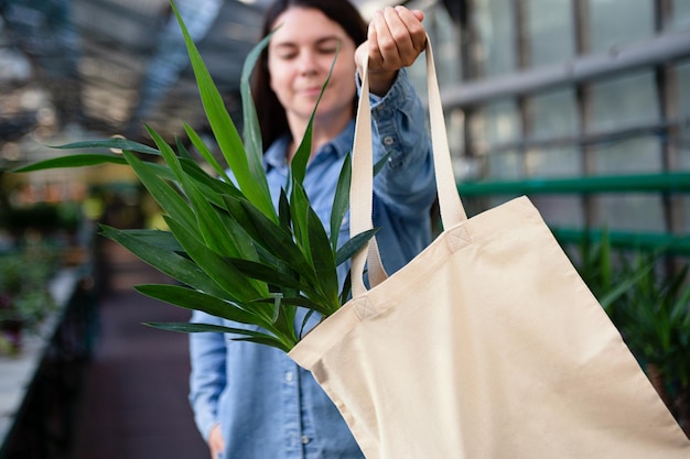 Photo woman holding eco friendly bag with yucca in itgood for text overlay