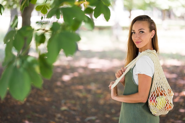 Donna che tiene una borsa ecologica con lo spazio della copia