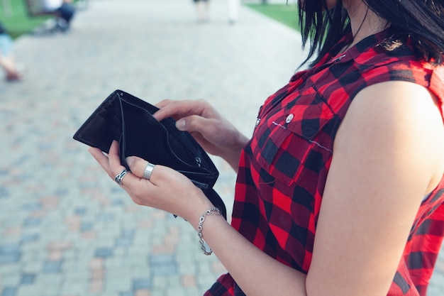 Woman holding empty wallet in the street