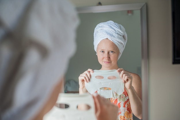 woman holding a facial mask sheet