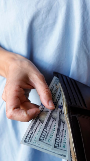 Photo woman holding few 100 dollar bills from the wallet