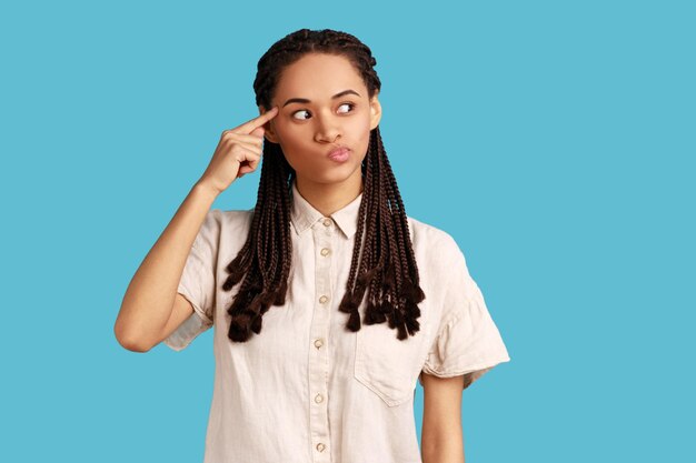 Woman holding finger near head temple and gesturing stupid idiot looking displeased with crazy idea