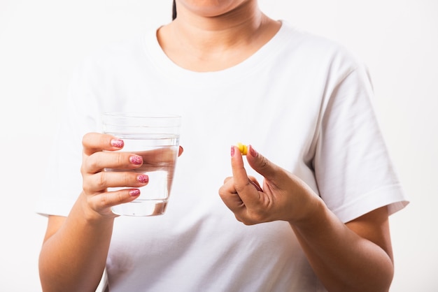 Woman holding fish oil vitamins with a glass of water