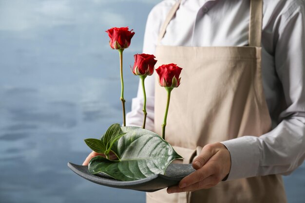 色の背景に花の構成を保持している女性