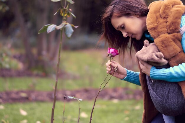 Foto donna che tiene un fiore in piedi all'aperto