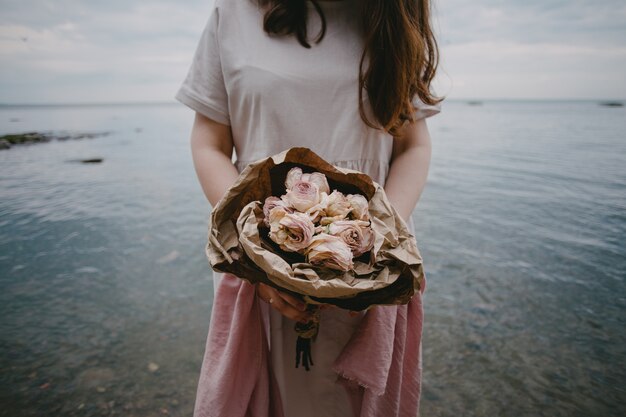 海で花を抱く女性