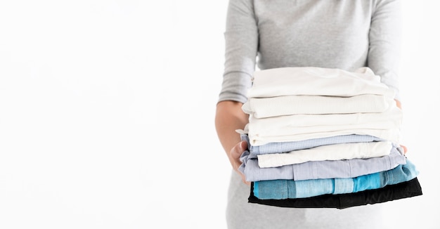 Photo woman holding folded laundry copy space