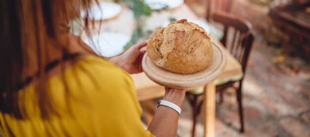 Woman holding fresh loaf of bread