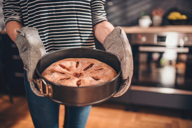 Donna che tiene la torta di mele di recente cotta