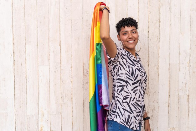 Woman holding a gay pride flag in support of Gay Pride in the street