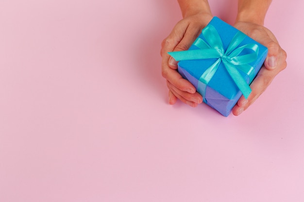 Woman holding gift box on color 