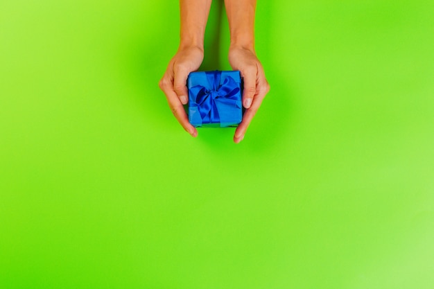 Woman holding gift box on color