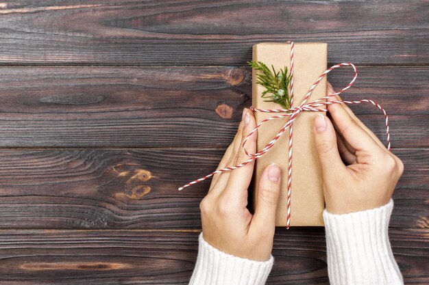 Woman holding a gift box in a gesture of giving