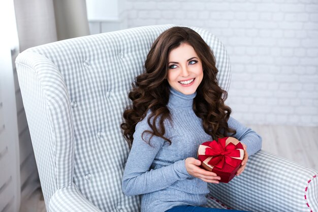 Woman holding a gift box shaped like a heart