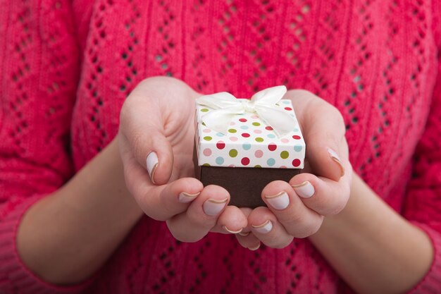 Woman holding gift box with ribbon