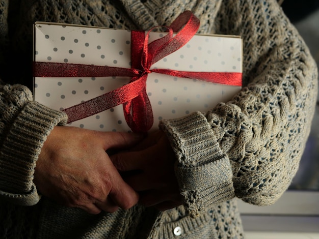 Woman holding a gift tied with a red bow