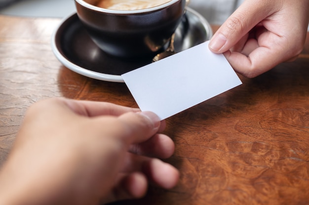 A woman holding and giving empty business card to someone