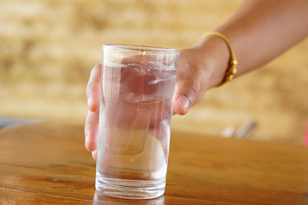 Woman holding a glass of water on the table