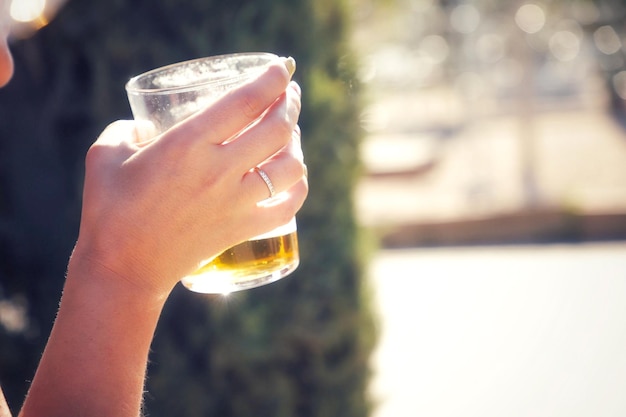 A woman holding a glass with beer