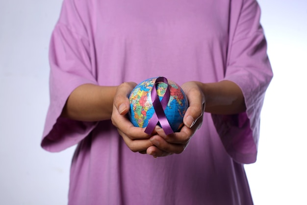 Foto donna che tiene un globo con un nastro viola per il concetto della giornata mondiale contro il cancro