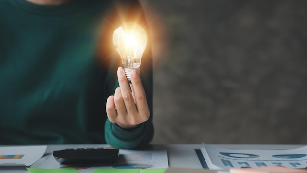 Woman holding glowing lamp creative new idea innovation\
brainstorming strategizing to make the business grow and be\
profitable concept execution strategy planning and profit\
management