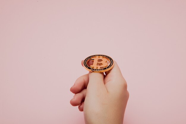 輝く新しいゴールドビットコインを保持している女性