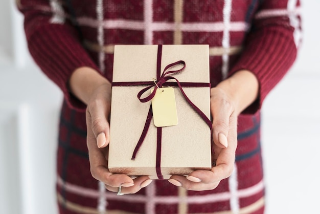 Foto donna che tiene un regalo d'oro con una carta