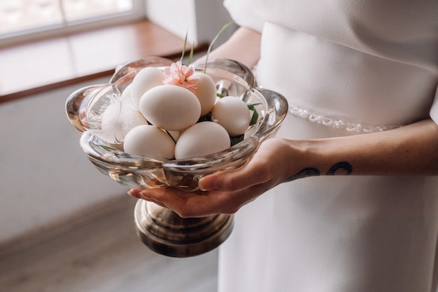 皿にガチョウの卵を保持している女性