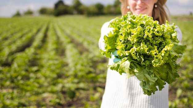 Woman holding a green vegetable with copy space